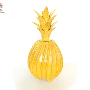 Op de afbeelding: Een gele keramische ananasvormige container met een getextureerd oppervlak en een gedetailleerde ananas bovenkant.