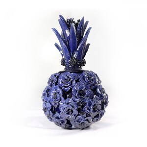 Könnte beinhalten: Eine handgefertigte, kobaltblaue Keramik-Ananas-Vase. Die Vase hat eine strukturierte Oberfläche mit detaillierten floralen Mustern und einer stacheligen Spitze. Ein einzigartiges dekoratives Stück, perfekt, um jedem Raum einen Hauch von Kunst zu verleihen.