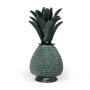 Puede incluir: Escultura decorativa de piña de cerámica de color verde azulado. La piña tiene un cuerpo texturizado, similar a un tejido, y una corona de hojas de color verde oscuro. Un artículo de decoración único.