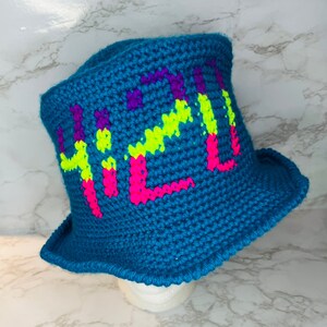 May include: A blue crocheted bucket hat with the word "420" in neon pink, green, and purple yarn.