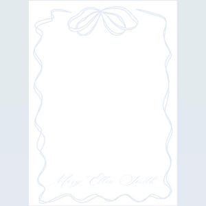 May include: A white stationery card with a light blue decorative border and a light blue bow at the top. The text "Mary Ellen Smith" is written at the bottom of the card.