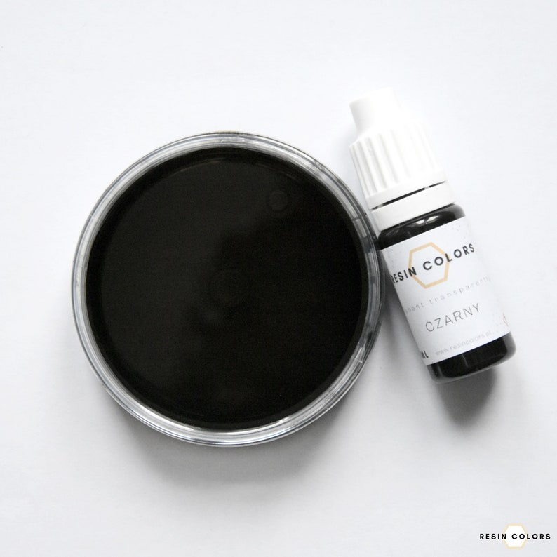 May include: A top-down view of a black resin dye and a bottle of resin dye. The dye is in a clear plastic container and the bottle has a white cap and a label that reads "RESIN COLORS" and "CZARNY".