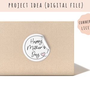 May include: A white round sticker with the text "Happy Mother's Day" in black script with a small pink heart. The sticker is on a brown package.