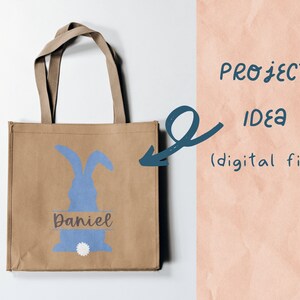 May include: A brown tote bag with a blue bunny silhouette and the name "Daniel" printed on it. The bag is a project idea for a digital file.