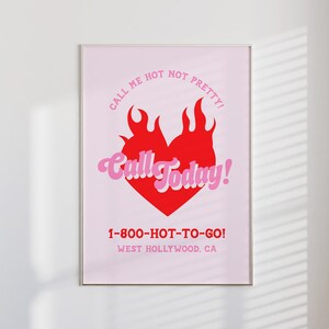 Puede incluir: Un póster rosa y rojo con un corazón en llamas y el texto "Call me hot not pretty! Call Today! 1-800-HOT-TO-GO! West Hollywood, CA"