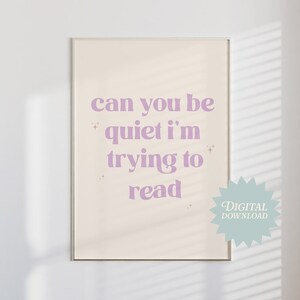 Puede incluir: Una descarga digital imprimible de un póster con el texto "Can you be quiet I'm trying to read" en una fuente de color púrpura claro sobre un fondo beige.