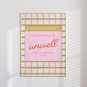 May include: A framed print with a pink and green plaid background. The print features a pink rectangle with the words "Your Email Finds Me unwell" in red script. The text "to whom it may concern" is at the top, and "please try again later. or dont!" is at the bottom.
