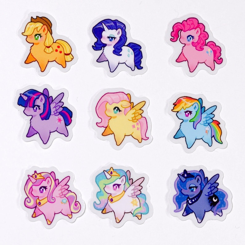 May include: Nine cartoon pony stickers in various colours. Each pony has a unique design, with different manes, tails, and accessories. The stickers are on a white background and are suitable for decorating various items.