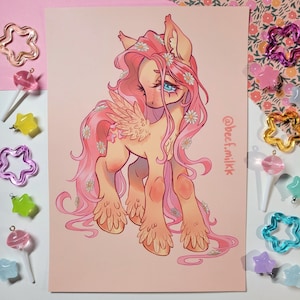 May include: A pink and yellow cartoon pony with a flower crown and wings. The pony has blue eyes and a pink mane and tail. The background is a light pink colour. The text "@beef.milk" is in the bottom right corner of the image.