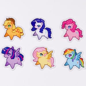 May include: Six colourful cartoon pony stickers. Each pony has a unique design, including different hair colours, wings, and cutie marks. The ponies are in shades of pink, blue, yellow, and purple, with rainbow accents.