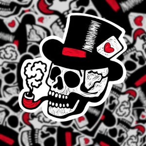 May include: A black and white illustration of a skull wearing a top hat with a red band and a playing card with a heart on it. The skull is smoking a pipe with white smoke coming out of it.