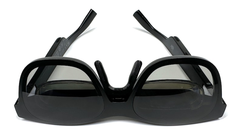 May include: Black 3D glasses with a foldable design. The glasses have a dark gray lens and a black frame.