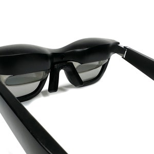 May include: Black framed glasses with a gray lens and the word "air" printed on the side of the frame.