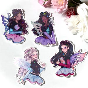 May include: A collection of stickers featuring illustrations of fairies. Each fairy has long hair, wings, and is wearing a black top, a skirt, and a long-sleeved shirt. The stickers have a watercolor style with glitter accents.