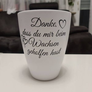 Könnte beinhalten: Weißer Keramik-Pflanztopf mit schwarzem Text, der "Danke. ♡ dass du mir beim Wachsen geholfen hast" lautet.