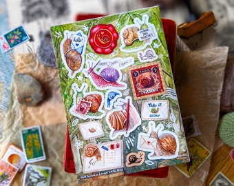 May include: A sheet of colorful snail stickers with illustrations of snails, leaves, and flowers. The stickers feature phrases like "Happy Snail Mail", "Take it Slow", and "Thank You Postie!"