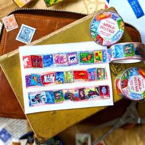 May include: Three rolls of colorful washi tape with a vintage postage stamp design. The tape features images of butterflies, flowers, and other designs. The text on the tape reads "World Postage" and "Washi Tape".
