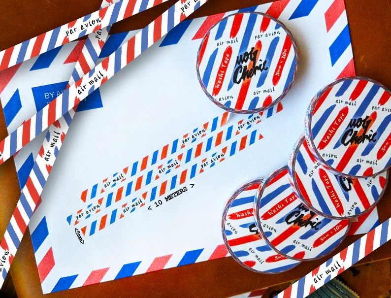 May include: A set of five rolls of washi tape with a red, white, and blue striped pattern. The tape is labeled "Washi Tape" and "Joly Cherie" in black lettering. The tape is 5 cm wide and 10 meters long.
