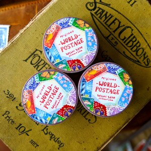 May include: Three rolls of colorful washi tape with a vintage world postage stamp design. Each roll is 20mm wide and 10 meters long. The tape features a variety of stamps with different countries and denominations.