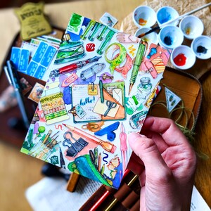 Puede incluir: Una ilustraci&oacute;n acuarela de una variedad de art&iacute;culos de papeler&iacute;a, que incluyen bol&iacute;grafos, l&aacute;pices, tijeras, cinta adhesiva y una libreta con la palabra "&iexcl;hola!" escrita en ella. La ilustraci&oacute;n est&aacute; sobre un fondo blanco y tiene un estilo colorido y caprichoso.