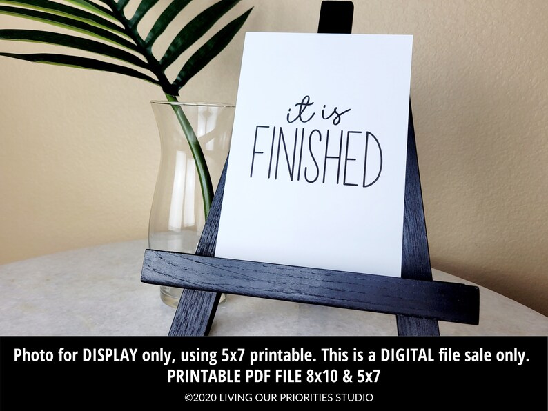 May include: A white printable sign with black text that reads "it is FINISHED". The sign is displayed on a small black easel. The sign is available in 8x10 and 5x7 sizes.
