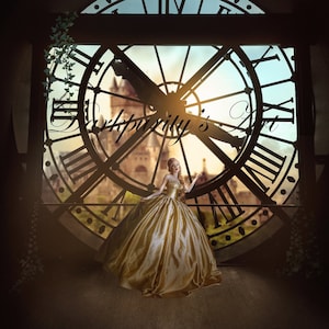 May include: A woman in a gold gown stands in front of a large clock face. The clock face is framed by a black metal frame and has Roman numerals around the edge. The woman is looking to the right and has her hand on the clock face.
