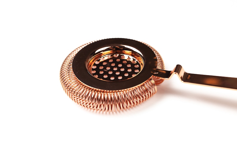 May include: A copper cocktail strainer with a spring-coil design and a handle. The strainer has a fine mesh screen.