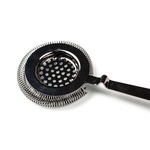 May include: A silver cocktail strainer with a spring-coil design around the edge and a fine mesh screen. The strainer has a long, thin handle.
