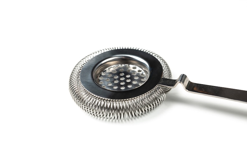 May include: A silver cocktail strainer with a spring-coil design and a handle. The strainer has a round, perforated base.