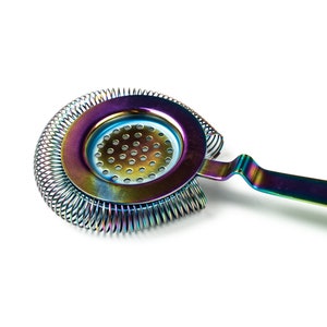 May include: A rainbow-colored cocktail strainer with a spring-coil design and a handle. The strainer is made of metal and has a circular shape with a perforated center.