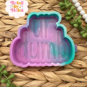 May include: A colorful, marbled silicone mold with the words "ur dumb" in a playful font. The mold is in shades of purple, teal, and blue. The image also includes a logo that says "Retail by Hales".