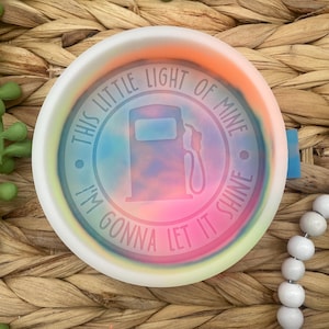 May include: A white ceramic dish with a tie-dye design and the text "This little light of mine, I'm gonna let it shine."  The dish features a gas pump silhouette in the center.