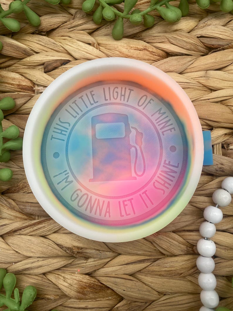 May include: A white ceramic dish with a tie-dye design and the text "This little light of mine, I'm gonna let it shine."  The dish features a gas pump silhouette in the center.