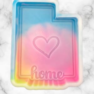 Peut inclure: Un moule en silicone en forme de l'&eacute;tat de l'Utah, aux couleurs de l'arc-en-ciel, avec un c&oelig;ur et le mot "home" &agrave; l'int&eacute;rieur.
