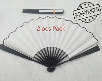 May include: Two white folding fans with black trim and black handles. The fans are closed and the text "2 pcs Pack" is printed on the front of the fans.