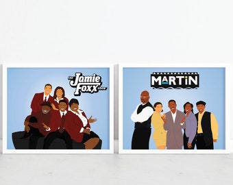 May include: Two framed art prints featuring cartoon illustrations of the casts from the TV shows "The Jamie Foxx Show" and "Martin". The prints have a light blue background and white frames. The Jamie Foxx Show print shows the cast in red suits.