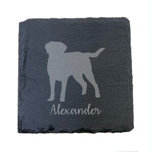 May include: Black slate coaster with a gray silhouette of a dog and the name "Alexander" engraved in gray.