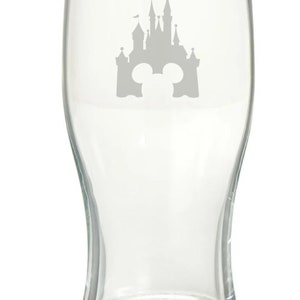 May include: A clear glass pint glass with a silhouette of Cinderella's castle and Mickey Mouse ears etched on the front.
