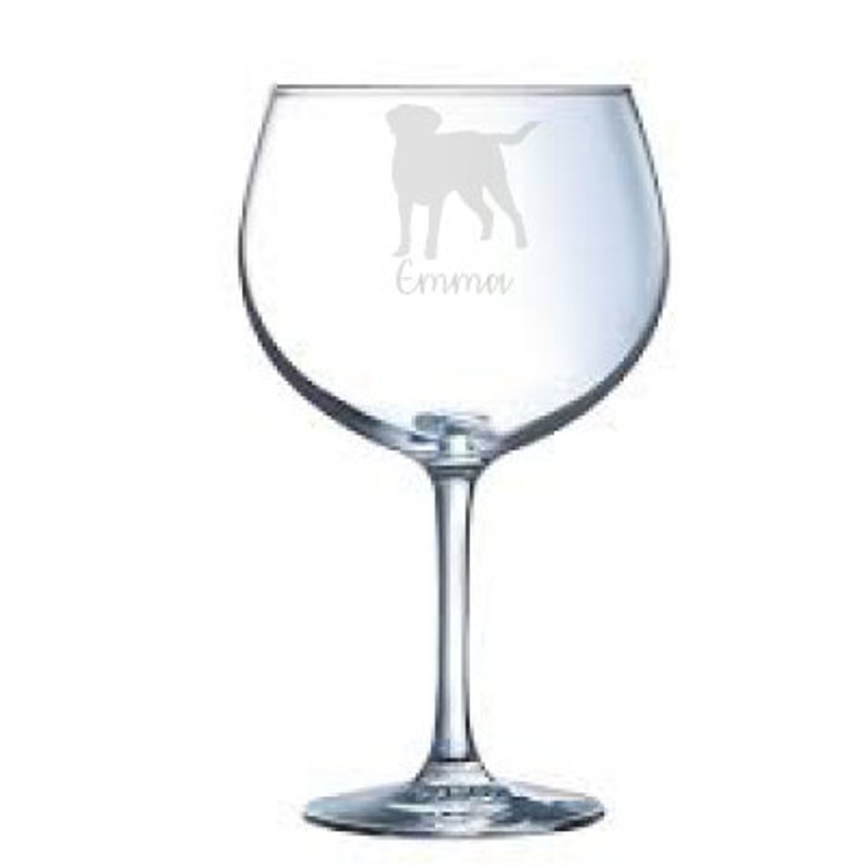 May include: A clear glass wine glass with a silhouette of a dog and the name "Emma" etched on the side.