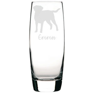 May include: A clear glass champagne flute with an etched silhouette of a dog and the name "Emma" on the side.