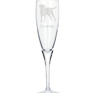 May include: A clear glass champagne flute with an etched silhouette of a Labrador Retriever and the name "Emma" underneath.