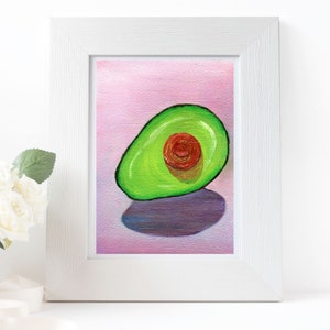 Puede incluir: Una pintura de un aguacate verde con un hueso rojo sobre un fondo rosa. El aguacate está sentado sobre una sombra morada.