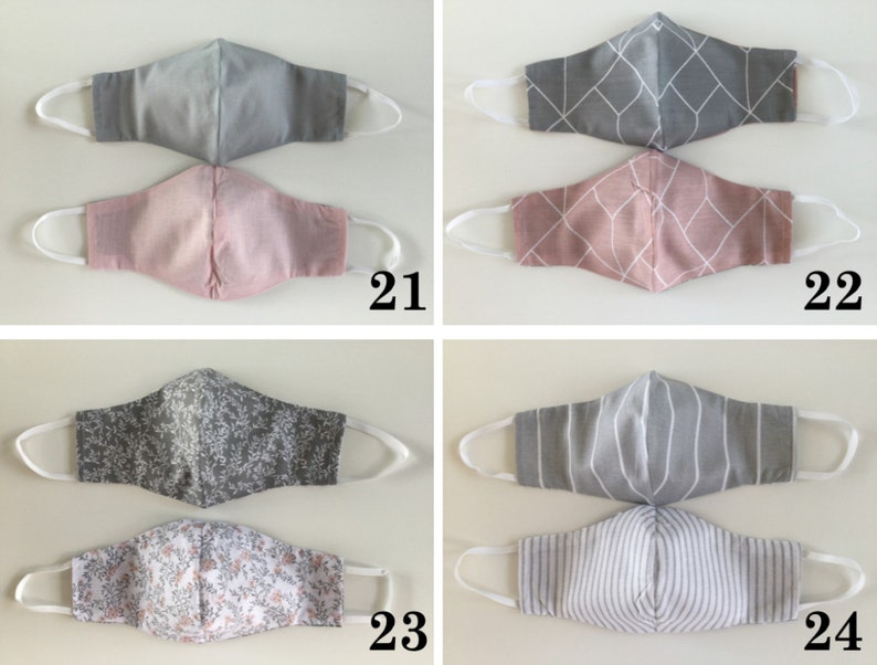 May include: Four pairs of fabric face masks with different patterns. The masks are gray and pink with geometric, floral, and striped patterns. The masks are numbered 21, 22, 23, and 24.