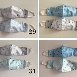 May include: Four pairs of face masks with a white and blue patterned design. The masks are made of fabric and have white elastic ear loops. The masks are numbered 29, 30, 31, and 32.