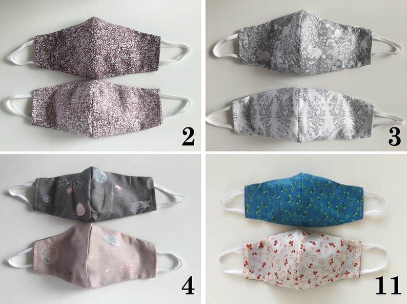 May include: Five pairs of fabric face masks with different patterns. The masks are all white with various colored patterns. The patterns include a gray and white geometric pattern, a gray and white floral pattern, a gray and white space pattern, a blue and white floral pattern, and a red and white floral pattern.