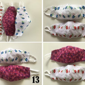 May include: Three pairs of reusable face masks with floral patterns. The masks are made of two layers of fabric, one white and one pink or blue. The masks are numbered 12, 13, and 14.