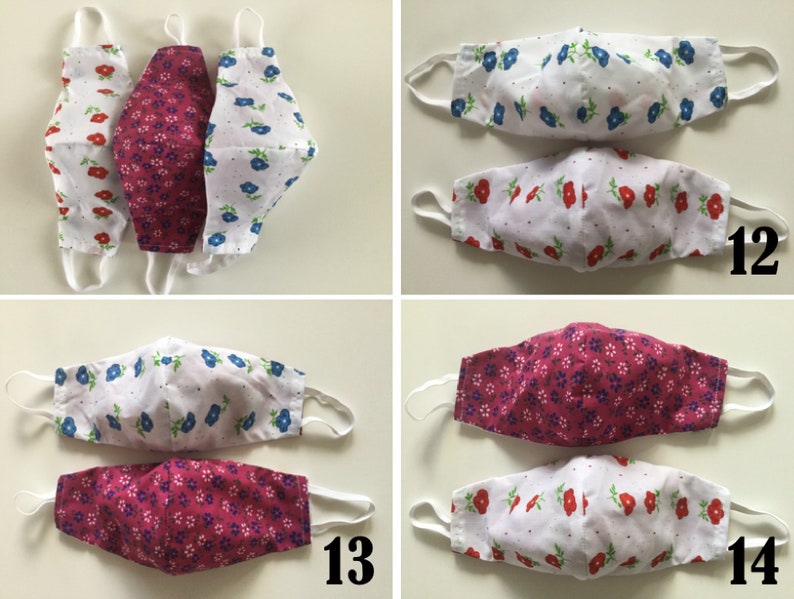 May include: Three pairs of reusable face masks with floral patterns. The masks are made of two layers of fabric, one white and one pink or blue. The masks are numbered 12, 13, and 14.