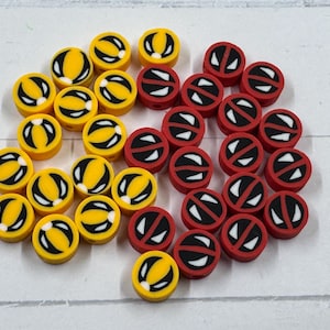 Op de afbeelding: Een verzameling gele en rode ronde kralen. De gele kralen hebben een zwart-wit ontwerp, terwijl de rode kralen een wit-zwart ontwerp hebben. Deze kralen zijn geschikt voor het maken van sieraden en knutselen.