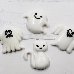 May include: Five white Halloween-themed resin charms.  The charms include three ghosts with different facial expressions, and two cats.  The charms are perfect for adding a spooky touch to crafts and projects.