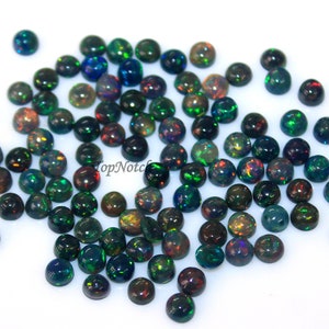 May include: A collection of 50 black opal cabochons, each measuring 6mm in diameter. The opals have a dark base with flashes of green, red, and blue.